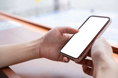Cropped shot of female hand holding blank screen smartphone, can enter text Image for advertising mediaの写真素材