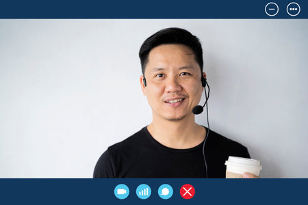 Man student teacher tutor wear wireless headset video conference calling on laptop computer talk by...