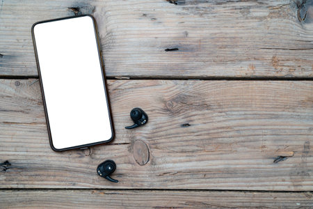 Mobile accessories arrangement band black wireless headphones, wireless headphones android mobile top blank wooden backgroundの写真素材