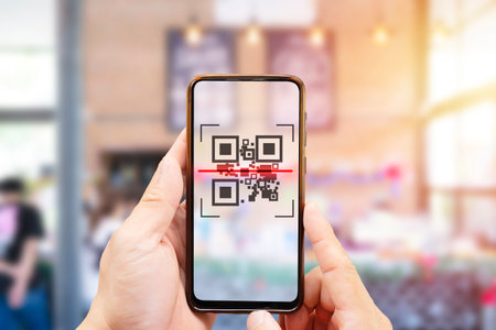 Modified inactive QR Code used. Person scanning QR code with smartphone to register details before...