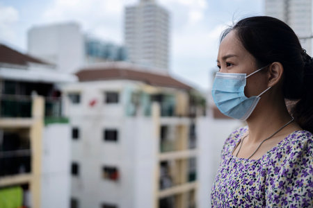Woman wearing face mask because of Air pollution or virus epidemic in the cityの写真素材