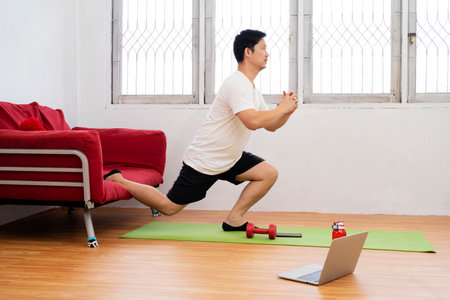 sport and healthy lifestyle concept - smiling indian man with fitness tracker exercising and doing squats at homeの写真素材