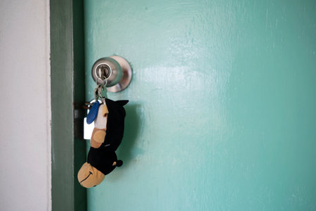 Home key with house keyring in keyhole on wooden door close upの写真素材
