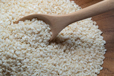 Sesame in a wooden bowl with a wooden or bamboo spoonの写真素材