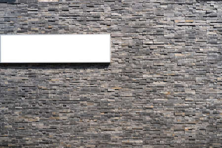 Empty information sign on white isolated background on gray old brick wall.の写真素材