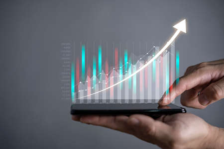 Hot business growth. Businessman using tablet analyzing sales data and economic growth graph chart. Business strategy, financial and banking. Digital marketing.の写真素材