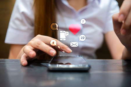 Person using a social media marketing concept on mobile phone with notification icons of like,...