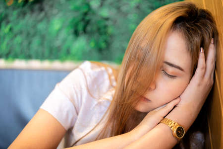 Work was too hard. Exhausted young woman freelancer napping by home office desk after difficult long workday.の写真素材