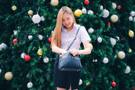 Merry Christmas And happy holidays, a cute beautiful woman decorated the Christmas tree the morning before Christmas.の写真素材