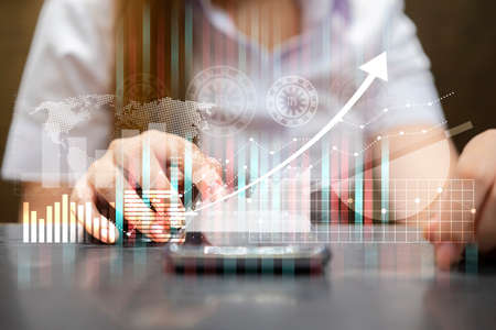 Attractive smiling businesswoman or stock trader analyzing stock graph chart using smartphone with...