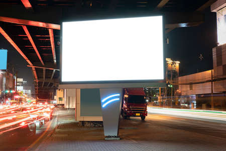 Blank billboard on light trails, street and urban in the night - can advertisement for display or montage product or business.の写真素材