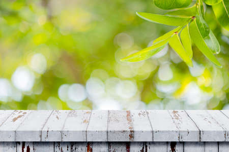 Empty wooden table with blurred natural bokeh background. Beautiful nature view green leaf on...