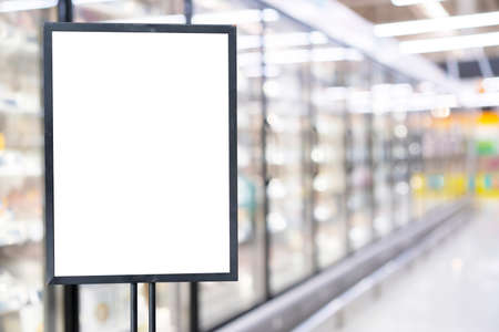 Blank poster frame template in supermarket. Blurred background and green filter of supermarket or grocery for priceの写真素材