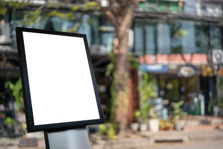 Blank white outdoor advertising stand, board mock up template. Clear street signage board placed by an outdoor dinning area of a restaurant. Background texture of standee on street.の写真素材