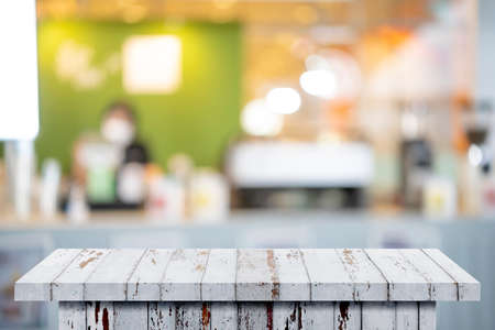 Wood table background, Shelf at cafe shop, Perspective wood over blur cafe with bokeh light background, Table for product display, Empty wooden counter in blur white room for mockup, banner, templateの写真素材