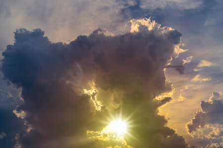Sky blue and orange light of the sun through the clouds in the skyの写真素材