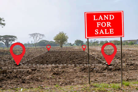 land for sale sign against trimmed lawn background. Empty dry cracked swamp reclamation soil, land plot for housing construction project in rural area and beautiful blue sky with fresh air.の写真素材