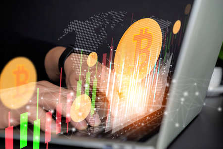 Use technology cryptocurrency blockchain, with capital gain, fundamental. Bitcoin cryptocurrency with pile of coins come out from stock chart candlestick on laptop.の写真素材