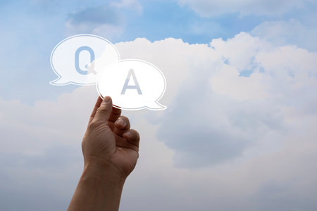 A businessman raises his hand to ask a question and wants an answer using the Q, A symbol on the sky background.の写真素材