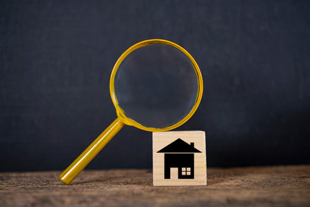 A magnifying glass is placed on a wooden block. House is on a wooden block. House searching, choice of location for construction, of mortgage, rental housing. home realtor business conceptの写真素材