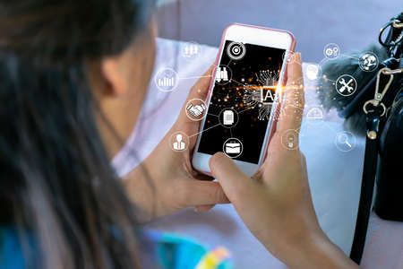 Artificial intelligence with AI text and various icon of smart city internet of things technology. Asian businesswomen happiness celebrating when doing online shoppingの写真素材