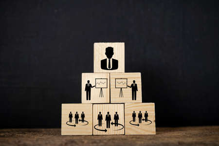 Wooden blocks placed on desk on blackboard background. Businessman icons signifying teamwork for success.の写真素材