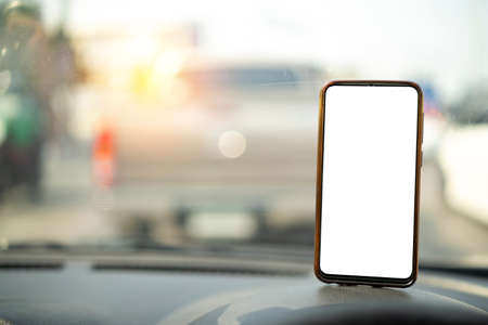 Cropped shot view of Smartphone in a car use for Navigate or GPS. Driving a car with Smartphone in holder. Mobile phone with white screen. Blank empty screen.の写真素材