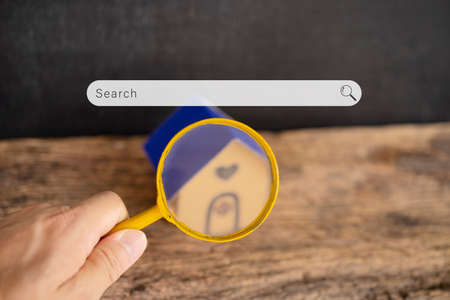 House searching concept with a magnifying glass. Searching browsing internet data information...