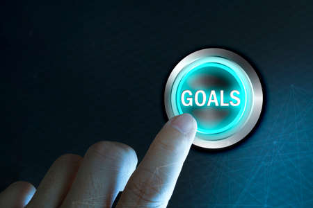 Businessman pressing button goals on virtual screen, networking concept.の写真素材