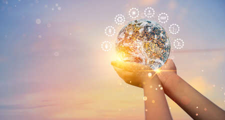 Earth at night was holding in human hands with energy resources icon. Earth day. Energy saving concept,の写真素材