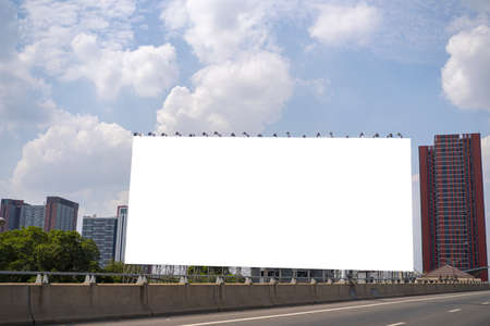 Blank white billboard against the blue sky in streets of city useful for designの写真素材