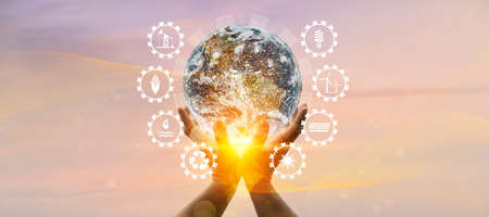 Earth at night was holding in human hands with energy resources icon. Earth day. Energy saving conceptの写真素材