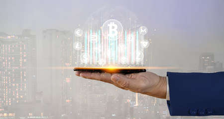 Businessman holding smartphone and showing virtual hologram of growth statistics, graphs and charts with Cripto currency, ethereum Crypto. Business growth stock market, planning and strategic ideas.の写真素材