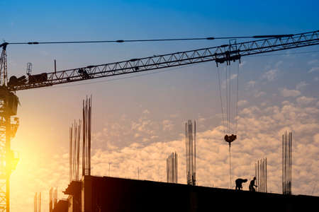 Silhouette Engineer standing orders construction crew working on high ground, heavy industry and safety concept over nature background pastel sunset blur.の写真素材