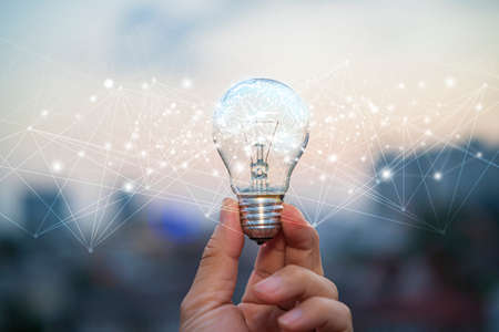 Creative thinking ideas and innovation concept. Businessman holding glowing lightbulb with drawing brain and connection lineの写真素材