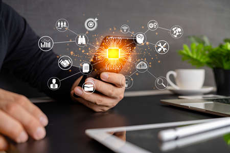 Digital marketing media in virtual screen.businesswoman hand working with mobile phone and modern compute with VR icon diagram at office in morning lightの写真素材