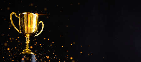 Golden metal glasses on old wooden table background, place for copy space. Ready for new year celebration design. Festive light background, first place, best win symbolの写真素材