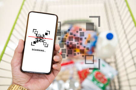 Man use smartphone scanning QR code for pay in supermarket.の写真素材