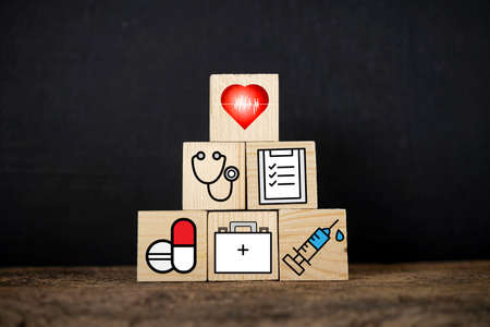 Medical icon on pyramid of cubes. medicine and health insurance concepts. Wooden blocks with icons of various types of insurance, icons healthcare medical symbol on wooden blockの写真素材