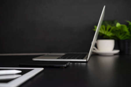 laptop with tablet and smartphone on black background, desk side viewの写真素材