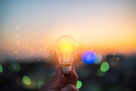 hands holding the light bulb that is illuminating with bulbs that shine glitter. Creative protecting patents and ideas concept.の写真素材