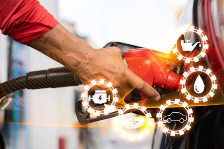 Oil refinery overlays and traffic lighting.Symbolic icons related to fuel energy.Refuel the car at the gas station at the gas station.The man refueled and refueled his car with gas at a gas station.の写真素材
