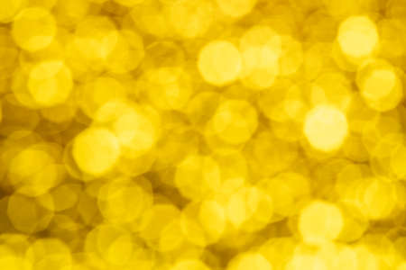 Gold abstract background with bokeh defocused lights. Abstract festive gold background with glowing bokeh lights.の写真素材