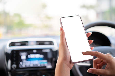 business woman busy driving hands holding phone with isolated screen in carの写真素材