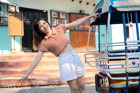 Woman traveler by tuk tuk look at Bangkok, Thailand. Woman riding a bus to travel in Thailand. The background is an old town.の写真素材