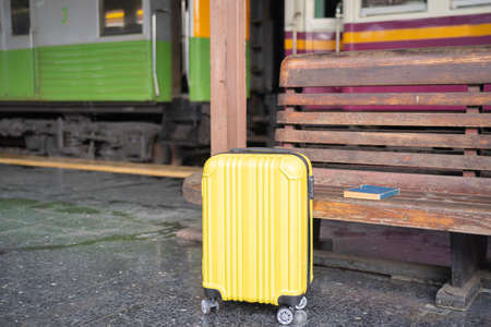 A yellow suitcase placed on the corridor of the train station for travel.の写真素材