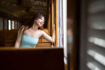 Beautiful girl in hat with a backpack sitting in the train. Traveling, journey.の写真素材