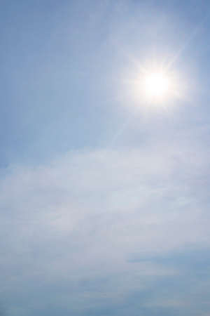 blue sky background with clouds, vertical. Bright sun in the blue skyの写真素材