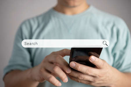 Men use smartphones to find what they are interested in. Searching information data on internet networking conceptの写真素材
