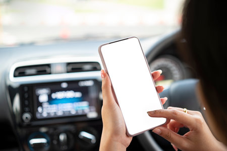 women hands holding phone with isolated screen in the car and is using fingers to touch the screenの写真素材